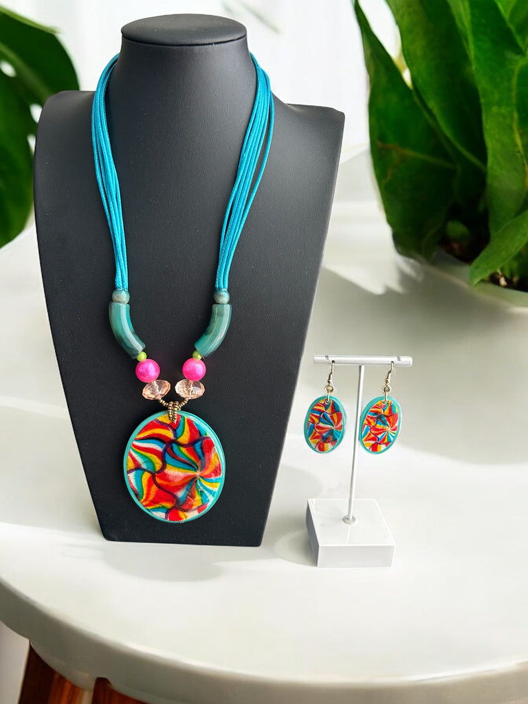 A turquoise necklace with multicolored beads and a teardrop pendant, displayed on a mannequin bust.
