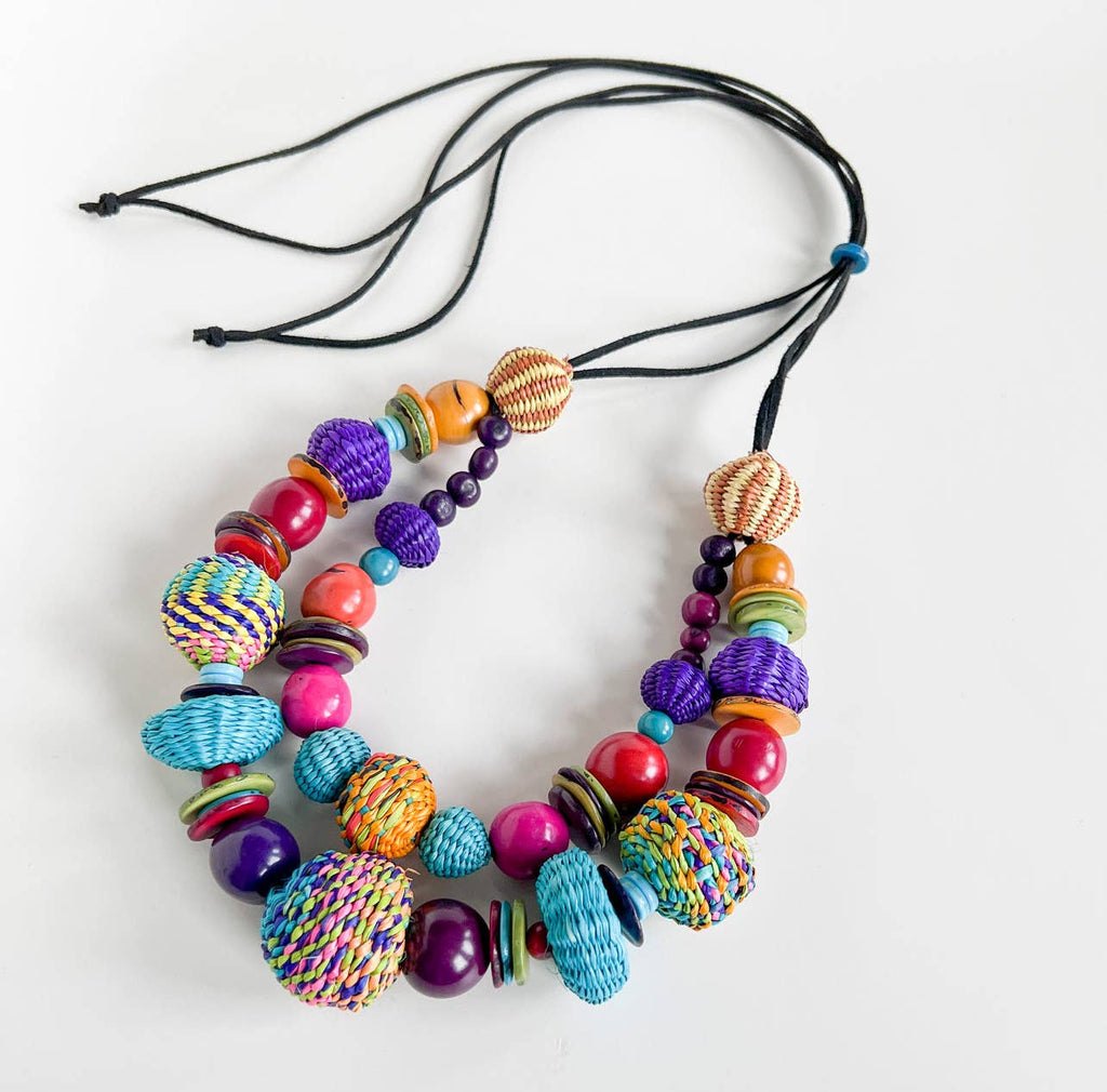 A colorful hand-woven double statement necklace made from recycled materials, featuring a variety of spherical beads in vibrant colors.